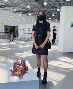Daniela junto a su obra en la exposición DOCUM3NTA M